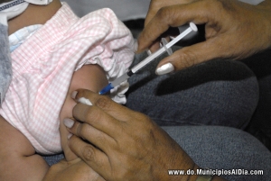 Enfermera aplica una vacuna de rigor a una bebita.
