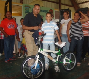 El diputado de ultramar del PRD, Ruben Luna, hace feliz a un niño de los cientos de la comunidad de Villa González, que se benefició del reparto de juguetes el día de los Reyes