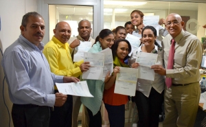 Momento en que parte del personal de la Federación Dominicana de Municipios FEDOMU, reciben su cheque de ahorro navideño de parte de los ejecutivos de COOPADOMU.