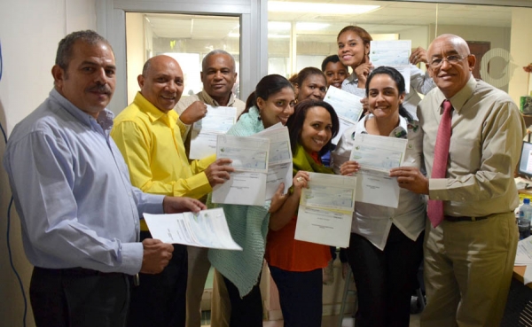 Momento en que parte del personal de la Federación Dominicana de Municipios FEDOMU, reciben su cheque de ahorro navideño de parte de los ejecutivos de COOPADOMU.