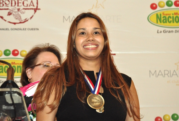 María Marte al momento de recibir la medalla que la acredita como "Orgullo de mi tierra" por parte de la señora Vicky Malla del Grupo CCN.