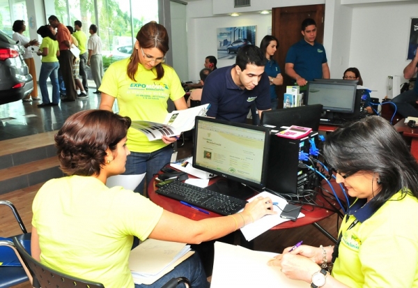 Oficiales de negocios de Banreservas atienden a clientes durante el  cierre de financiamientos para la adquisición de vehículos en la Expomóvil, celebrada el pasado fin de semana en todo el país. 