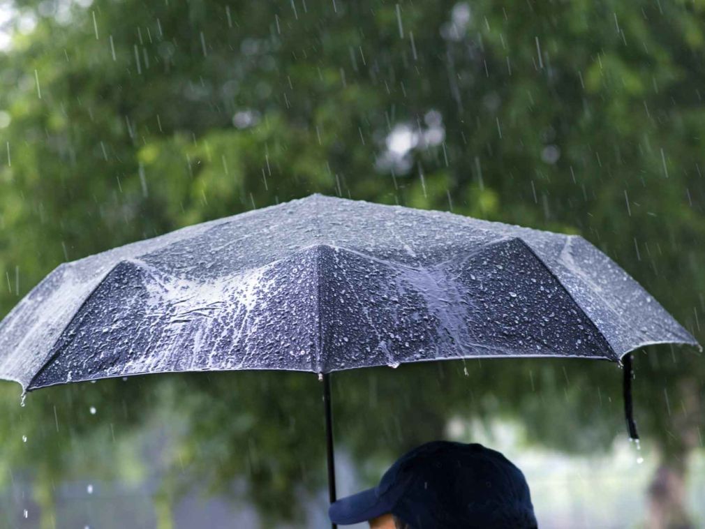 Persona se cubre de la lluvia con sombrilla.
