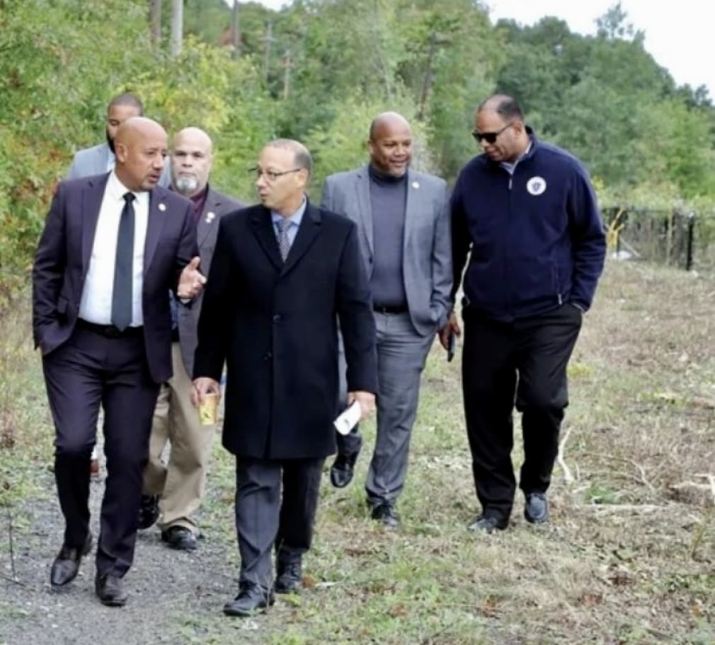 La foto presenta al Representante estatal, Frank Morán, el alcalde de Lawrence, Brian de Peña, y a varios Concejales mientras supervisaban la construcción del Lawrence &amp; Methuen que es parte de un corredor ferroviario abandonado de 30 millas que une a Lawrence y Manchester, New Hampshire.